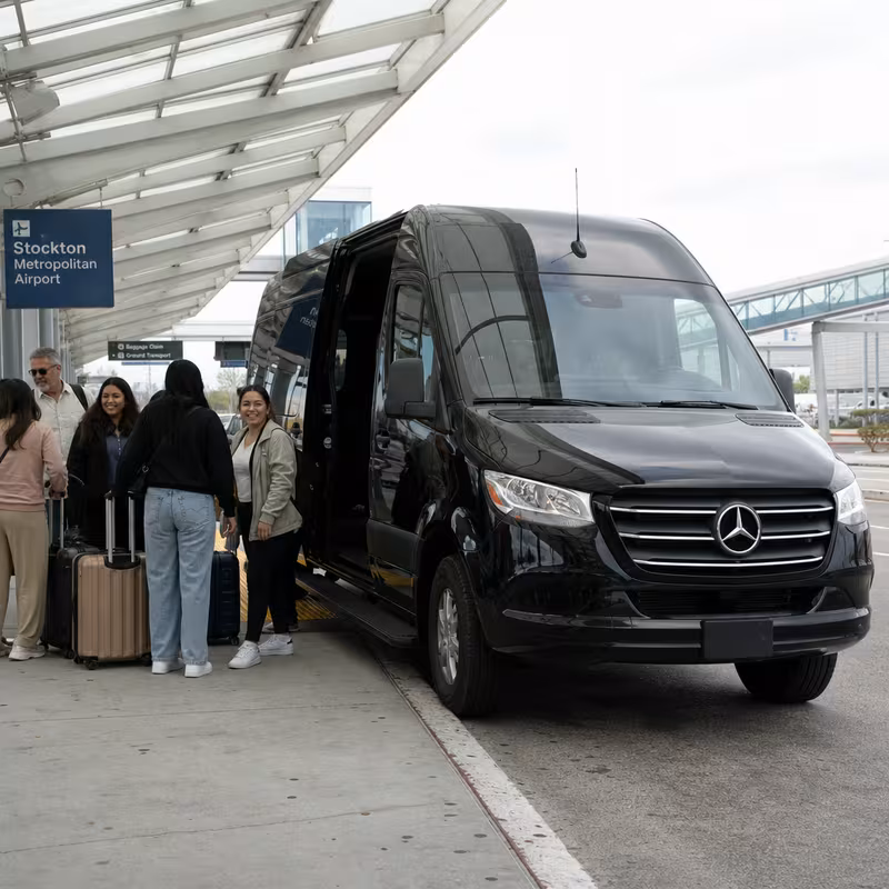 Group boarding a white charter bus for Airport Transportation transportation in Stockton