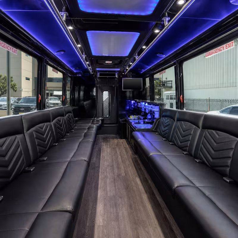 Party bus interior with wraparound leather seating and LED lighting in Stockton