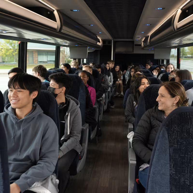 Group boarding a white charter bus for School Transportation transportation in Stockton