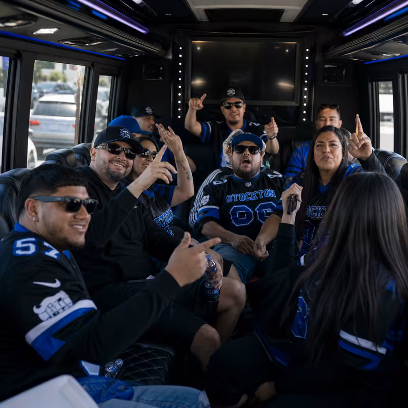 Group boarding a white charter bus for Sporting Event Transportation transportation in Stockton