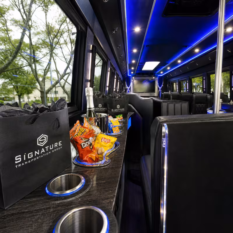 Party bus interior with wraparound leather seating and LED lighting in Stockton